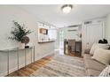 Cozy living room featuring hardwood floors and seamless transition to the modern kitchen and dining area at 1532 N High St # 1, Denver, CO 80218