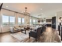 Open concept living room with modern chandelier and large windows with amazing views at 14440 Hop Clover Trl, Parker, CO 80134