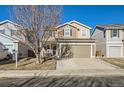 Two-story house with tan and brown siding, attached garage, and a landscaped front yard at 10699 Durango Pl, Longmont, CO 80504