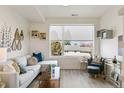 Inviting living room featuring a large window with natural light, cozy seating, and chic decorative elements at 5385 W 14Th Ave, Lakewood, CO 80214