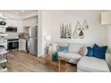 Cozy living room featuring modern decor, plush seating, and an adjacent kitchen area with stainless steel appliances at 5385 W 14Th Ave, Lakewood, CO 80214