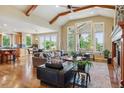 Open-concept living room with hardwood floors, beamed ceilings, and large windows at 4651 Sonado Pl, Parker, CO 80134
