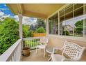 Cozy porch with two white chairs, small round table, and view of the green lawn and surrounding trees at 13112 Summit Grove Pkwy, Thornton, CO 80241