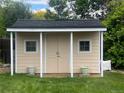Backyard shed with double doors and two windows, perfect for storage at 13112 Summit Grove Pkwy, Thornton, CO 80241