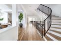 Bright foyer with hardwood floors and curved staircase with black iron railings at 2646 S Madison St, Denver, CO 80210