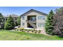 Exterior view of a home with a private balcony and staircase surrounded by lush greenery at 15088 Verbena St, Thornton, CO 80602