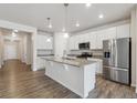 Bright kitchen features white cabinets, stainless steel appliances, granite counters, and a large island at 5385 Trails Edge Ln, Castle Rock, CO 80104