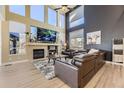 Inviting living room with a stone fireplace, large windows, and a comfortable leather seating area at 7378 Geode Ct, Castle Rock, CO 80108