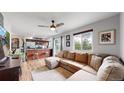 Open-concept living room featuring a comfortable sectional sofa and a breakfast bar with modern chairs at 10759 Clermont St, Thornton, CO 80233