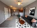 Inviting living room features a modern sofa, decorative rug, and a ceiling fan at 15700 E Jamison Dr # 3-202, Englewood, CO 80112