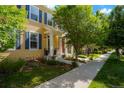 Charming two-story home with yellow siding, blue shutters, a well-maintained lawn, and mature trees at 8427 E 35Th Ave, Denver, CO 80238