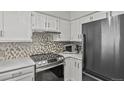 Modern kitchen with stainless steel oven, smooth cooktop, new appliances, white cabinets, and stylish backsplash at 13950 E Oxford Pl # A-104, Aurora, CO 80014