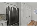 Updated kitchen features stainless steel refrigerator, white cabinets, hardwood floors, and stainless steel hardware at 13950 E Oxford Pl # A-104, Aurora, CO 80014