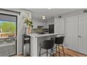 Open kitchen area with stainless steel appliances, breakfast bar with seating, and sliding door to the outside at 13950 E Oxford Pl # A-104, Aurora, CO 80014