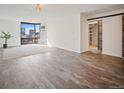 Bright living room with wood floors, large windows showcasing city views, and modern barn door access at 1625 Larimer St # 3004, Denver, CO 80202