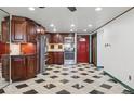 Bright kitchen with dark wood cabinets, stainless steel appliances, and unique black and white checkered flooring at 8822 E Florida Ave # G07, Denver, CO 80247