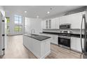 Bright, white eat-in kitchen features an island, stainless appliances, and lots of natural light at 7700 E 29Th Ave # 102, Denver, CO 80238