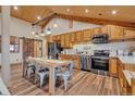 Eat in kitchen showcasing wooden cabinets, stainless steel appliances and wood flooring at 11524 Spruce Mountain Rd, Larkspur, CO 80118