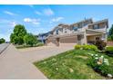 Well-kept townhome featuring a two-car garage, a driveway, and a manicured lawn at 6139 Raleigh Cir, Castle Rock, CO 80104