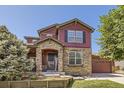 Charming two-story home with stone accents, covered entry, and a well-manicured front yard at 10811 Chambers Way, Commerce City, CO 80022