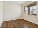 Well-lit bedroom with wood floors and a large window, ideal for relaxation and comfort at 9929 Ceylon Ct, Commerce City, CO 80022