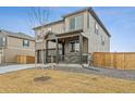 Side view of a charming two-story home with a covered front porch, two-car garage, and fenced yard at 9929 Ceylon Ct, Commerce City, CO 80022