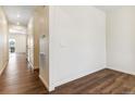 Bright hallway with wood floors leading to an open-concept living space at 9929 Ceylon Ct, Commerce City, CO 80022