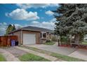Ranch-style home with a brick exterior, garage, and well-kept landscaping at 4391 W Tufts Ave, Denver, CO 80236