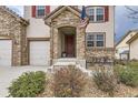 Inviting front porch with stone details, manicured landscaping, and a glimpse of the home's charming exterior at 10776 Hillsboro Cir, Parker, CO 80134