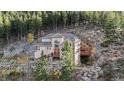 Secluded mountain home with stone accents and wooden deck nestled amongst trees at 900 Sawmill Creek Rd, Evergreen, CO 80439
