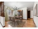 Elegant dining room featuring hardwood floors, large window, and a decorative chandelier for a formal ambiance at 2696 S Yukon Ct, Lakewood, CO 80227