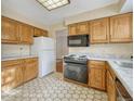 Galley kitchen with wood cabinets and hex floor tile at 8621 E Yale Ave # F, Denver, CO 80231