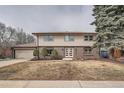 Traditional two-story home with brick and siding, attached two car garage and mature trees at 4055 S Niagara Way, Denver, CO 80237