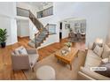 Bright, staged living room with high ceilings, wood floors, staircase, and adjoining dining room at 2180 Trailblazer Way, Castle Rock, CO 80109