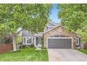 Beautiful two-story home with stone accents, a well-manicured lawn and a welcoming facade at 16341 Maple Rock Ct, Parker, CO 80134