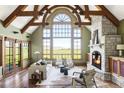 Bright living room with vaulted ceilings, exposed beams, stone fireplace, and expansive windows at 5101 Saint Vrain Rd, Longmont, CO 80503