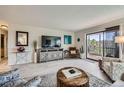 Cozy living room features wood-look floors, a balcony, and a decorative entertainment center at 14390 E Marina Dr # 403, Aurora, CO 80014