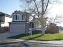Well-manicured front lawn with an inviting two-story house and attached garage, ready for new homeowners at 292 S Pembrook St, Castle Rock, CO 80104