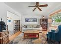Cozy living room with neutral sofa, wood coffee table, and a large window with natural light at 1395 S Kendall St, Lakewood, CO 80232