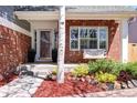Inviting front porch with a cozy swing, red brick accents, and beautiful landscaping at 13777 W Amherst Way, Lakewood, CO 80228