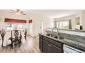 Eat-in kitchen featuring granite countertops, breakfast bar, and laminate flooring at 1148 Opal St # 101, Broomfield, CO 80020