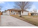 Exterior view of a cozy gray single-story home with a long driveway and front porch at 2713 S Hazel Ct, Denver, CO 80236