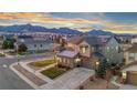 Beautiful two-story home featuring stone accents, a well-manicured lawn, and mountain views in the background at 19495 W 94Th Ave, Arvada, CO 80007