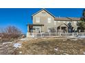 Two-story home with a snowy yard and a white picket fence at 3805 Windriver Trl, Castle Rock, CO 80109