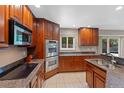 Modern kitchen with stainless steel double ovens, built in microwave and cooktop with granite countertops at 6143 S Ash E Cir, Centennial, CO 80121