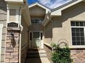 Inviting front entrance with stone accents and well-maintained landscaping, creating a warm welcome at 22312 E Plymouth Cir, Aurora, CO 80016