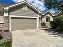 Home featuring a two-car garage and concrete driveway, complemented by stone and siding exterior at 22312 E Plymouth Cir, Aurora, CO 80016