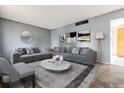 Cozy living room featuring a large gray sectional sofa and modern decor, perfect for relaxation at 14830 Robins Dr, Denver, CO 80239