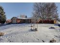 Brick ranch home with snow-covered lawn and mature trees at 3300 E Briarwood Ave, Centennial, CO 80122
