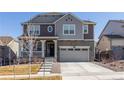Two story home featuring a covered porch, stone accents, and a two-car garage at 8240 S White Crow St, Aurora, CO 80016